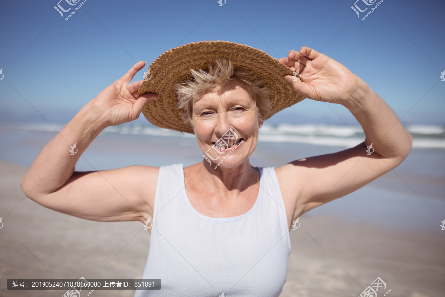 海滩上戴太阳帽的老年妇女