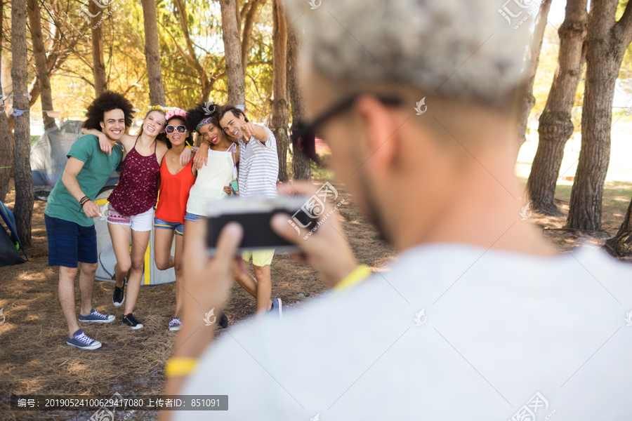 站在营地拍摄朋友的人的后视图