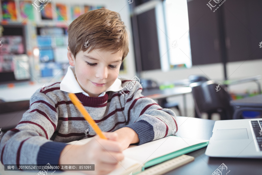 小学生坐在教室的课桌上学习