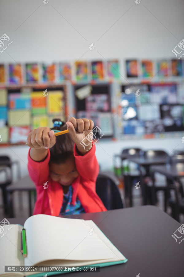 女孩坐在教室的课桌旁伸出手