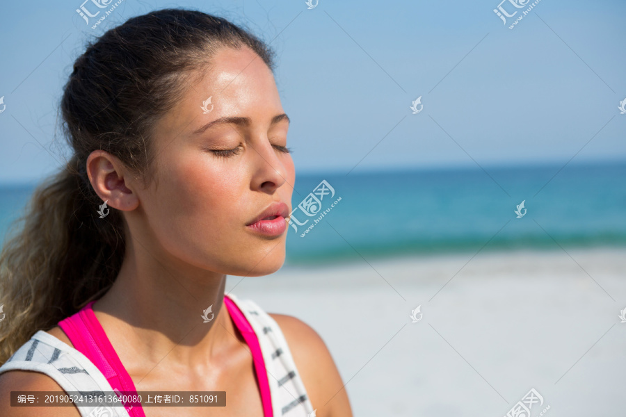 在沙滩上冥想的年轻女子