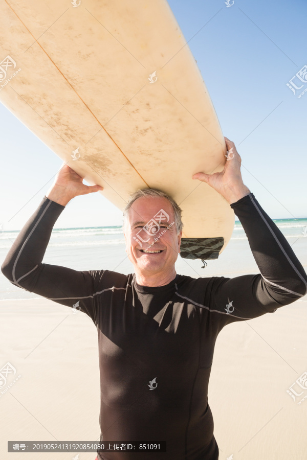 海滩上拿着冲浪板的老人肖像