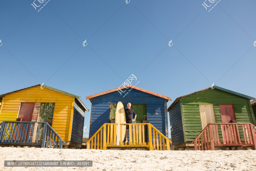 站在沙滩小屋旁的老年人