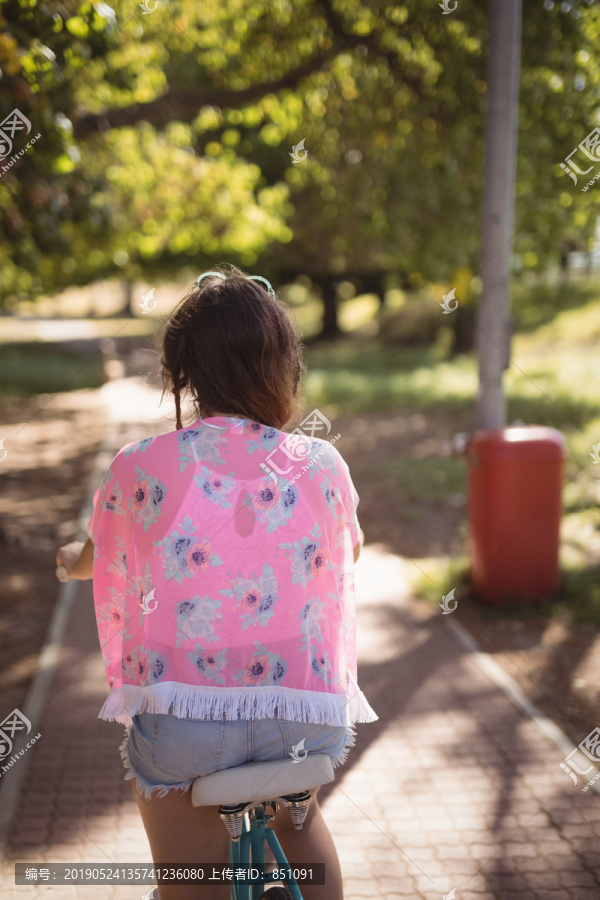 森林步道上骑自行车的女子