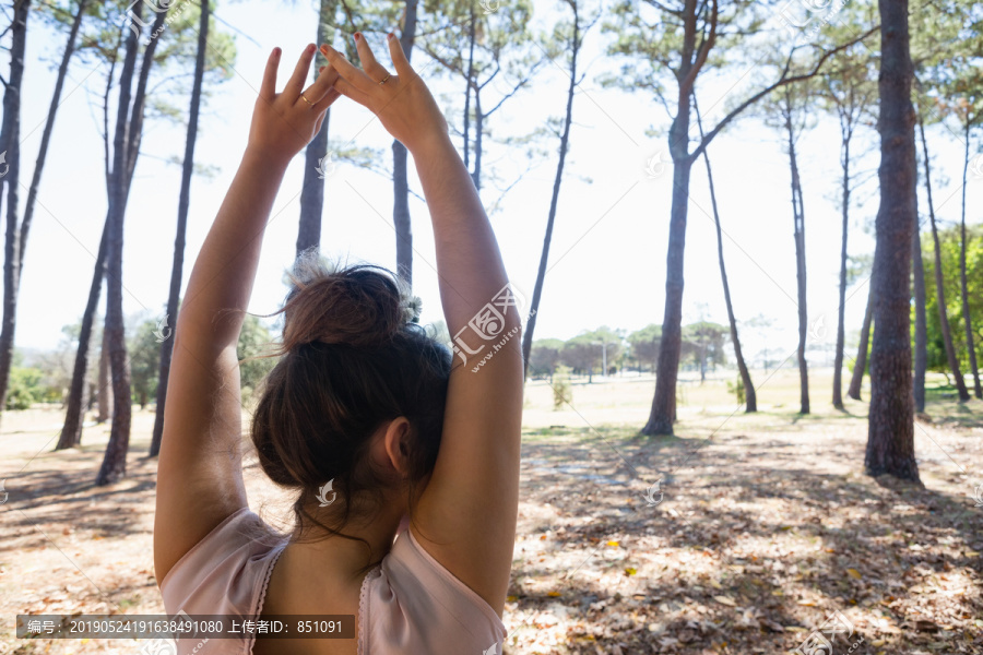站在公园里双臂举起的妇女