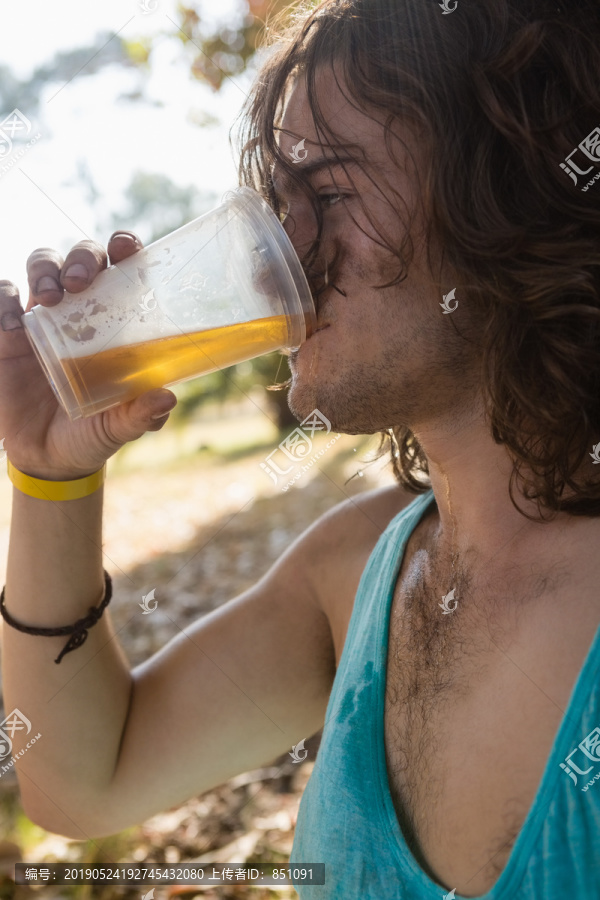 在公园里喝啤酒的成年男人