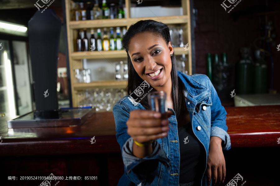在吧台上喝龙舌兰酒的快乐女人