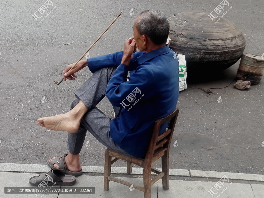 坐着用长烟斗抽烟的老人