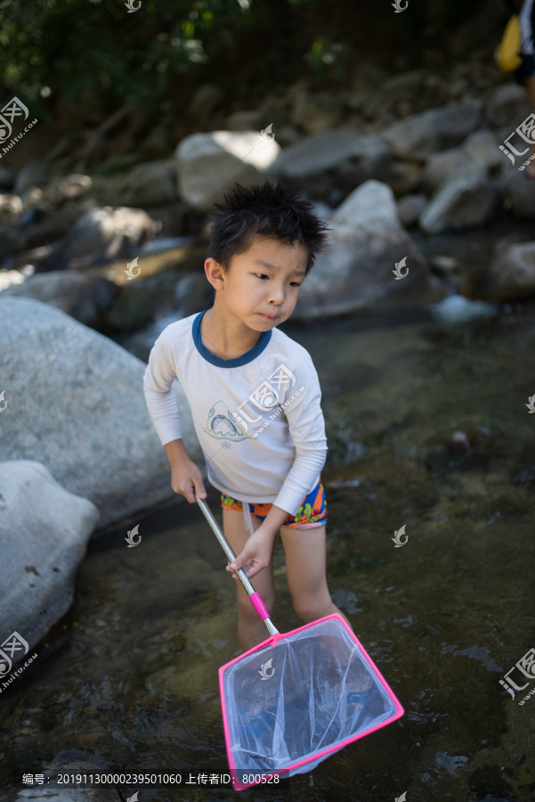 小男孩在河里捞鱼