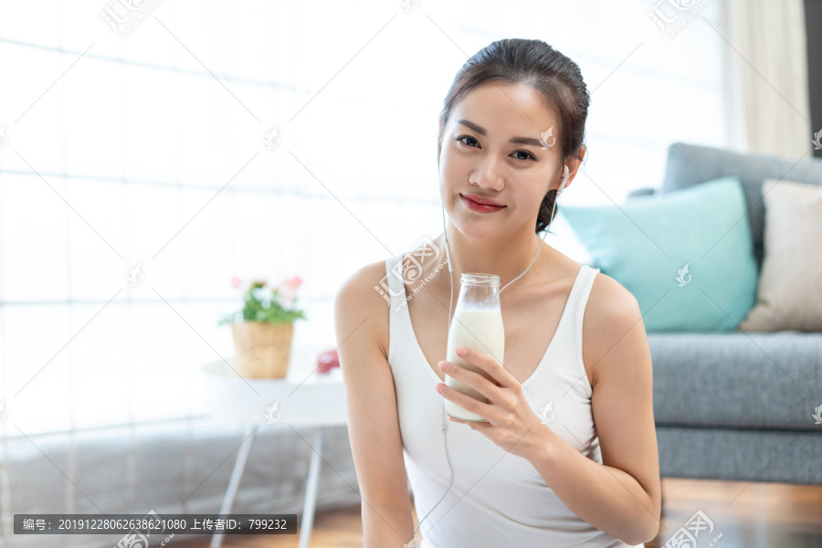 年轻女子锻炼后休息喝牛奶