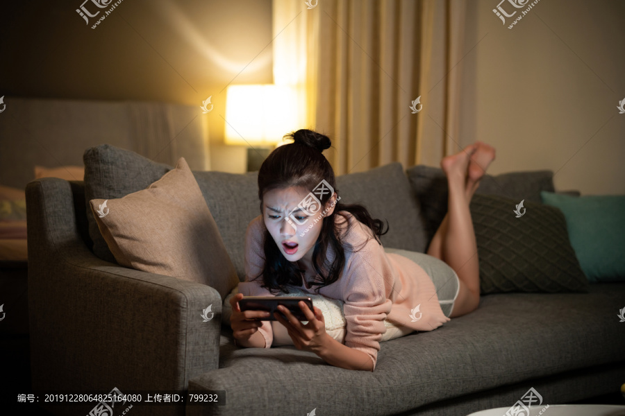 年轻女士在家玩手机游戏