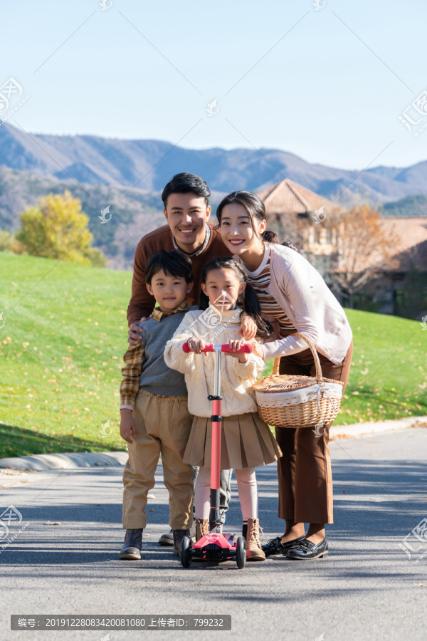 年轻夫妻带着孩子们在玩滑板车