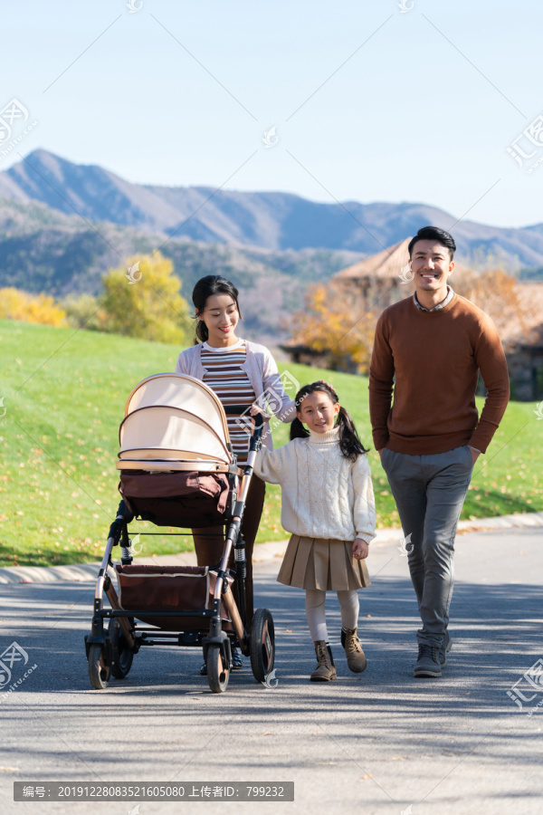 年轻夫妻推着婴儿车散步