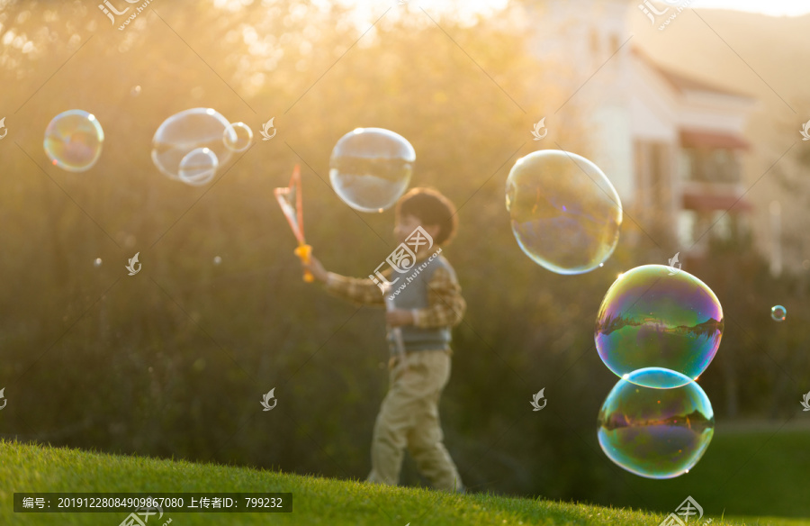 快乐的男孩在草地上玩泡泡
