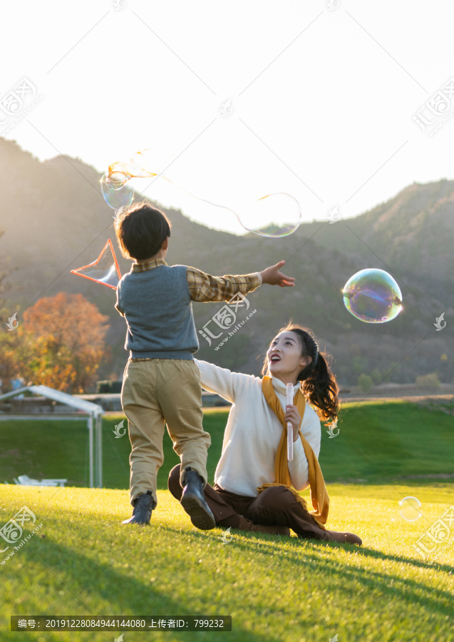 母亲和孩子在草地上玩泡泡