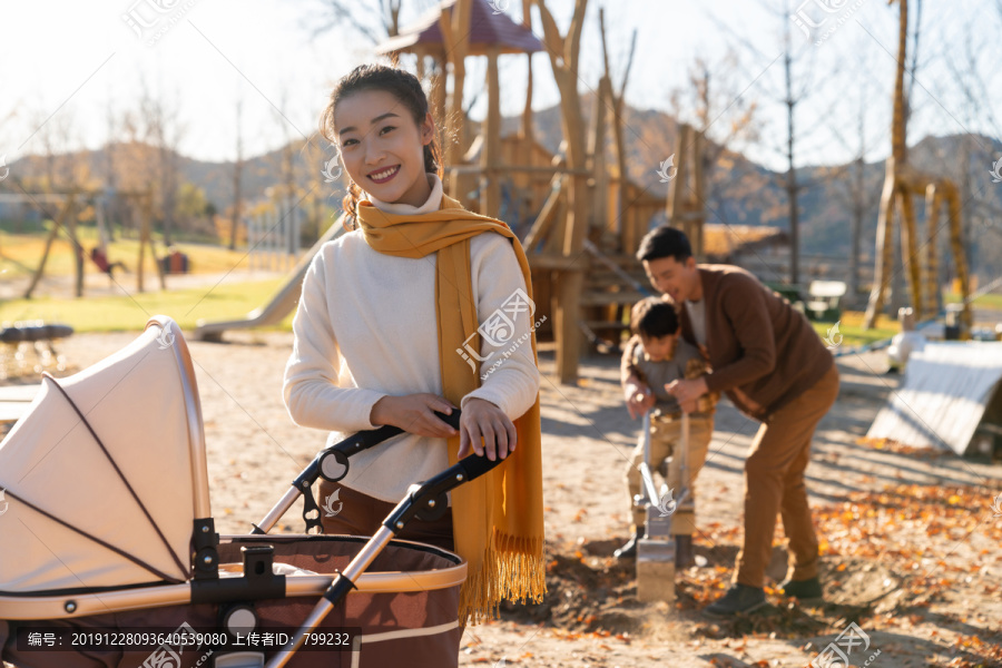 年轻家庭推着婴儿车散步