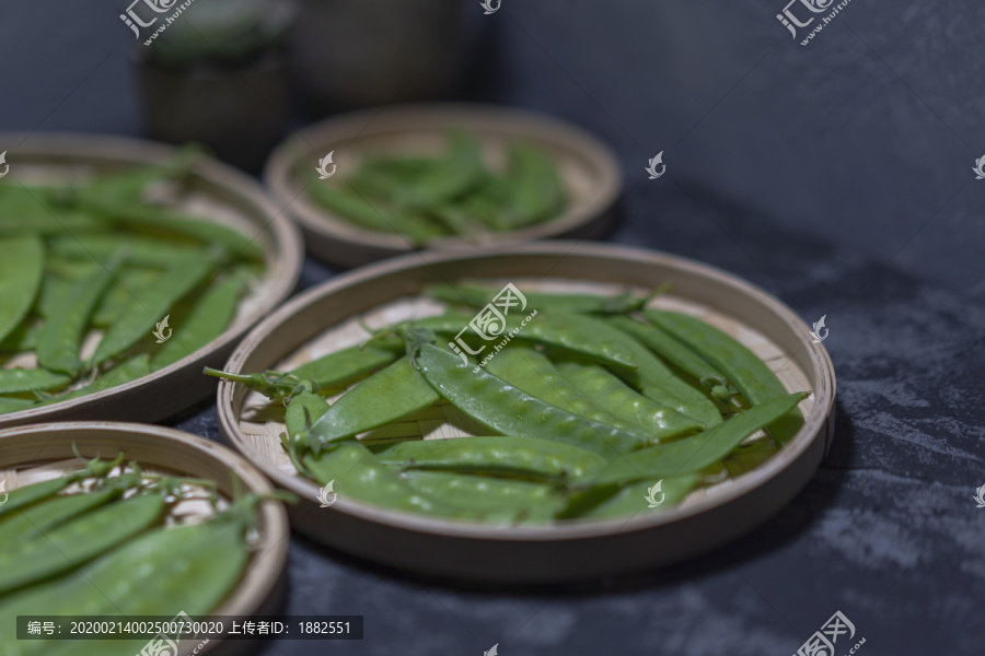 水泥背景草编盘中的荷兰豆蔬菜