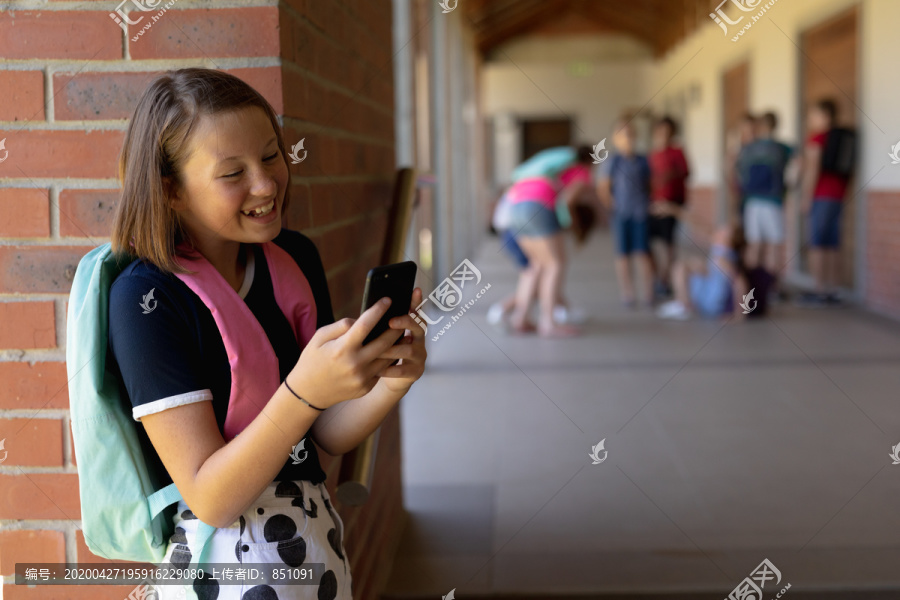 女学生背着背包靠在墙上