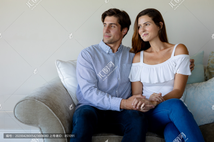 一对白人夫妇坐在客厅的沙发上