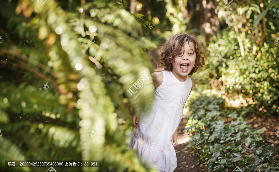 可爱的小女孩在热带花园里玩
