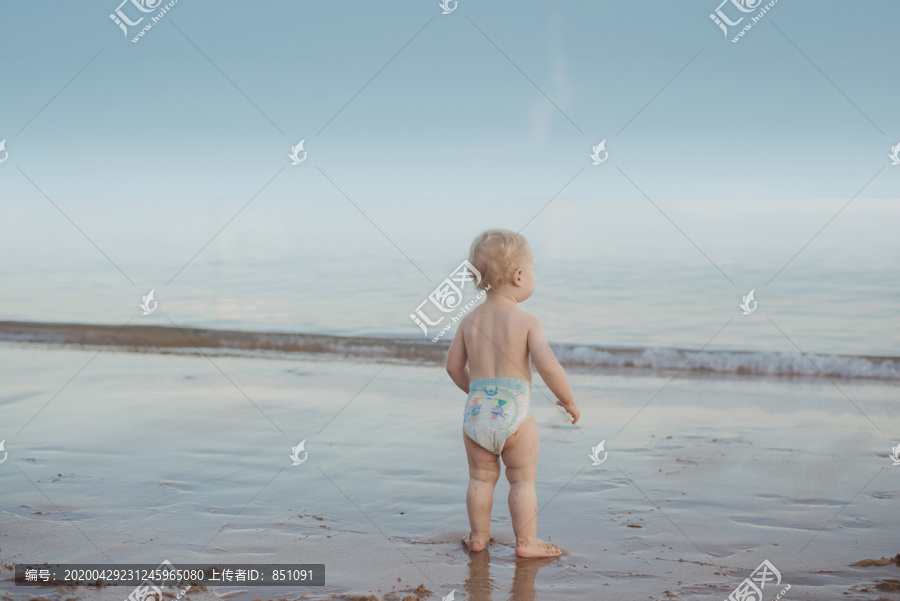 可爱的宝宝看着海浪
