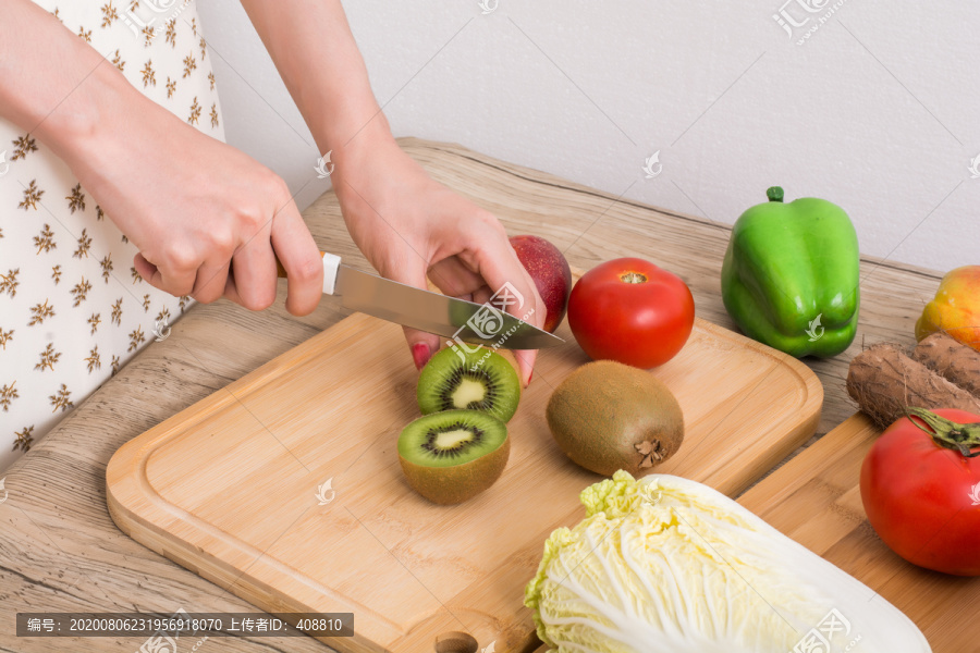 人在桌子上切新鲜蔬菜水果混搭配