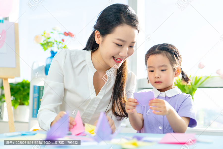 老师和小女孩一起折纸