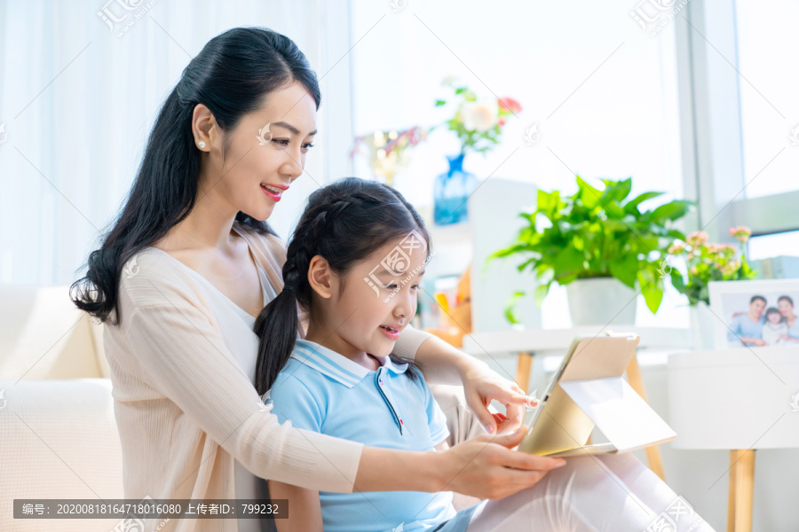 小女孩和妈妈一起使用平板电脑