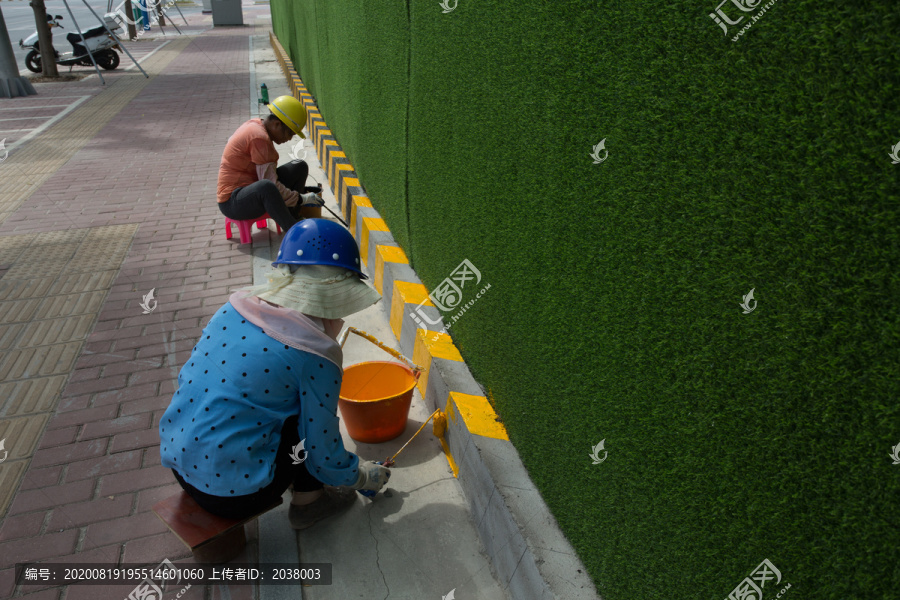 建筑工人在太阳下刷油漆