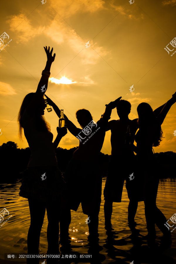 人们在落日的余晖中自由地在水里举行夏日派对