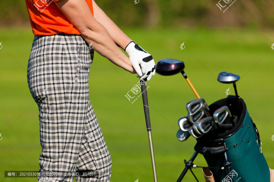 成熟的女人-只能看到躯干-拿着高尔夫球袋在高尔夫球场上打高尔夫球