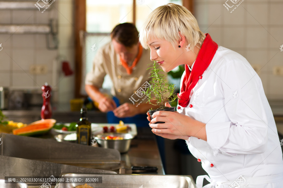 两个厨师团队合作-男人和女人-在餐厅或酒店厨房烹饪美味的食物
