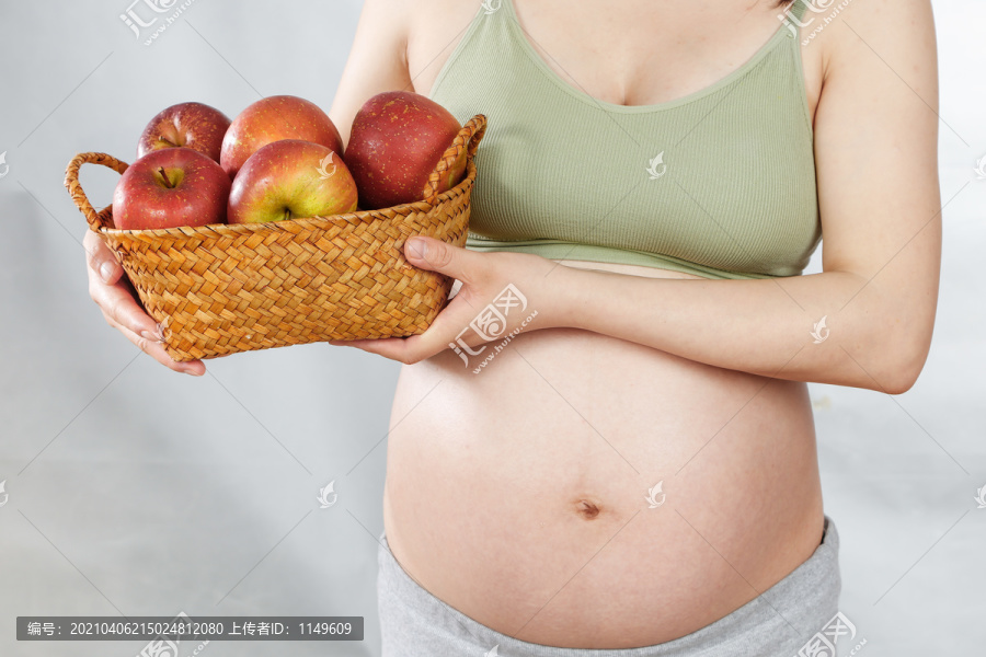 孕妇手上端着一蓝苹果