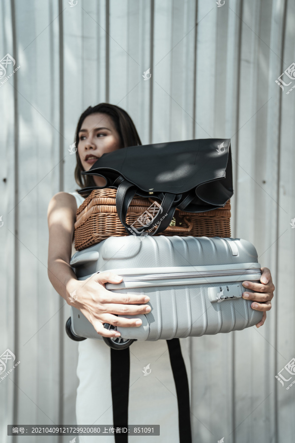 一位忙碌的亚泰妇女提着沉重的袋子和行李。坚强的女人。