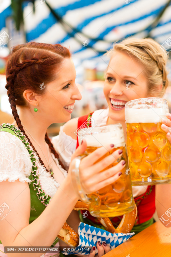 穿着传统巴伐利亚服装的年轻女性——迪恩德尔或特雷希特——在啤酒帐篷里参加节日或啤酒节