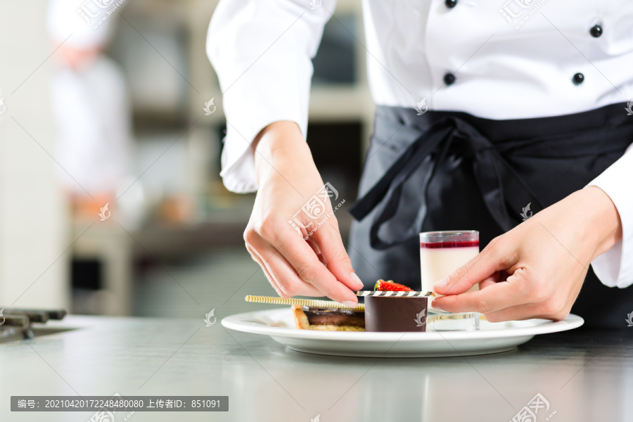 厨师，女糕点厨师，在酒店或餐厅的厨房烹饪时，她正在整理甜点