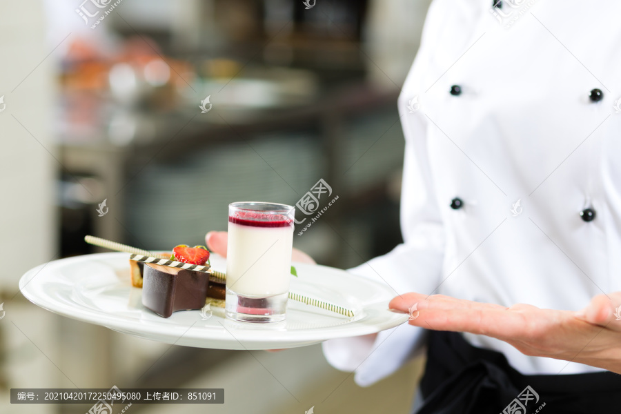 厨师，女糕点厨师，在酒店或餐厅的厨房烹饪时，她正在整理甜点