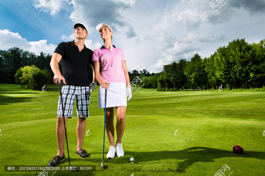 在高尔夫球场上打高尔夫的年轻运动型夫妇，他们当然锻炼或训练