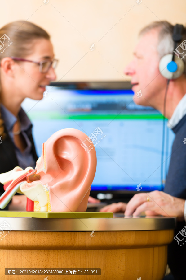 有听力问题的老年人或退休人员进行听力测试，可能需要助听器，前景是人耳模型