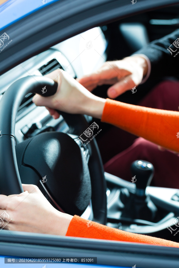 驾校——年轻女子用方向盘驾驶汽车，也许她有驾驶考试，也许她练习停车
