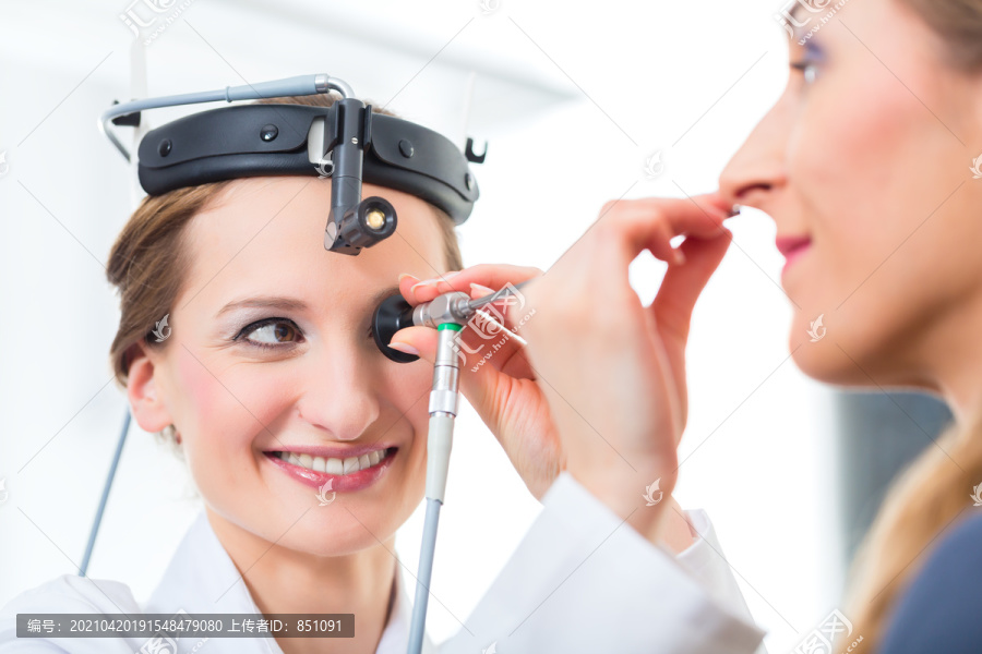医生-年轻的女性顾问或耳鼻喉科专家-与患者一起在她的诊所，用抹刀检查喉咙