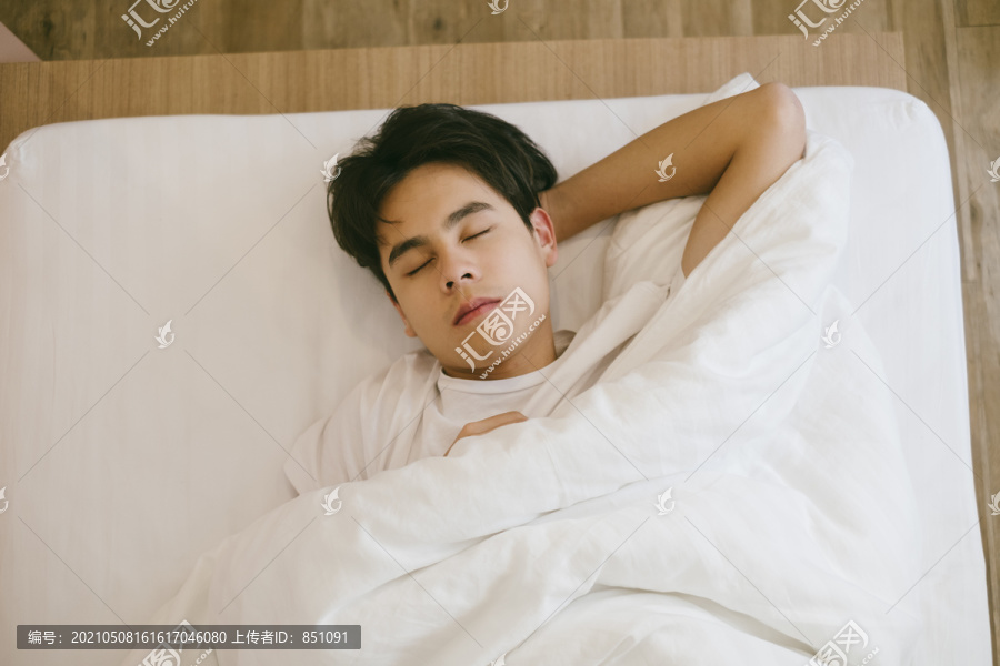 黑头发的家伙睡在床上，把头放在手上。