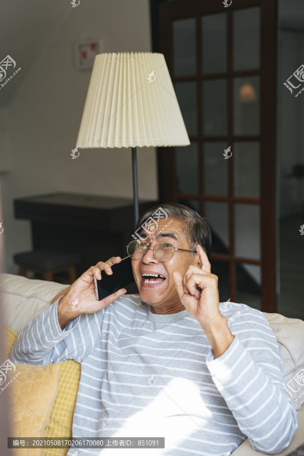 一位白发老人很高兴他能通过智能手机和他的孙子们交谈。