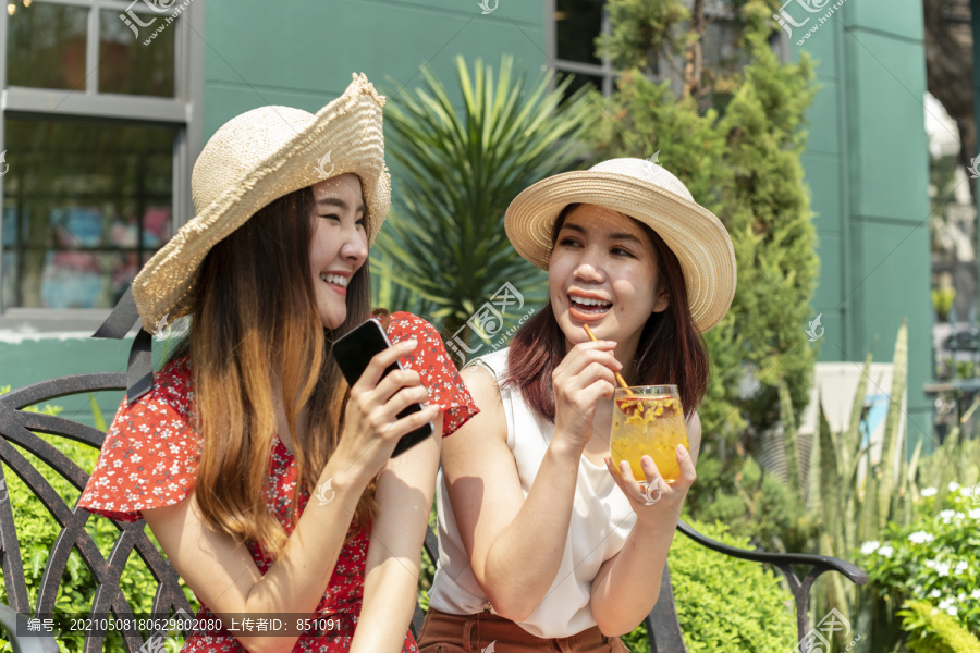 两个年轻漂亮的亚洲女人在度假时戴着帽子。一起去度假。