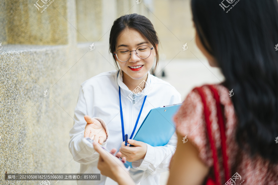 美丽的亚洲女导游与游客交谈并提供旅游信息。