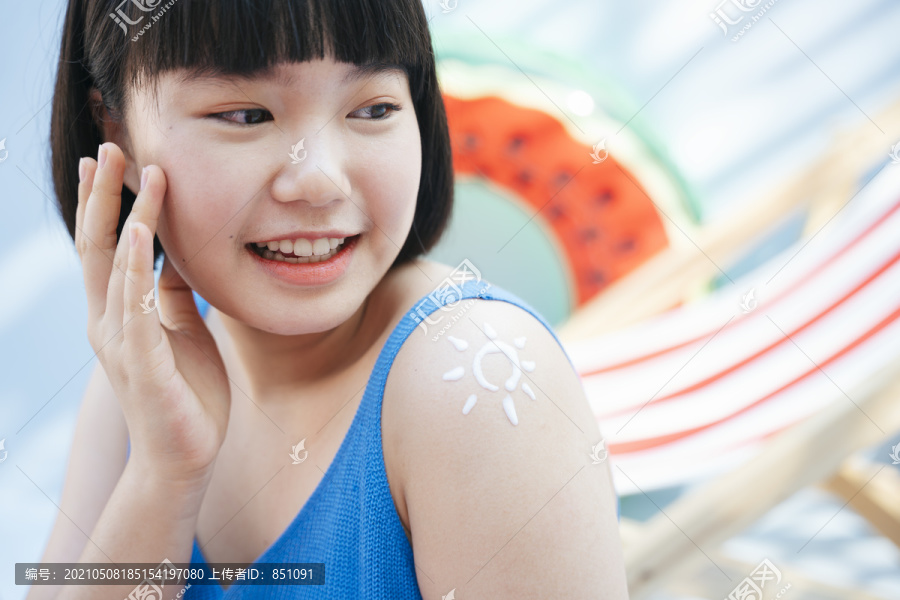 美丽的bob发型，穿着蓝色背心衬衫的亚洲女人，手臂上涂有防紫外线乳液。用奶油乳液在肩上晒成的太阳画。