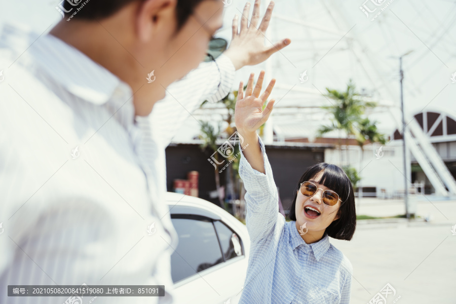 美丽的年轻亚泰女子鲍勃戴着太阳镜发型给司机高五。