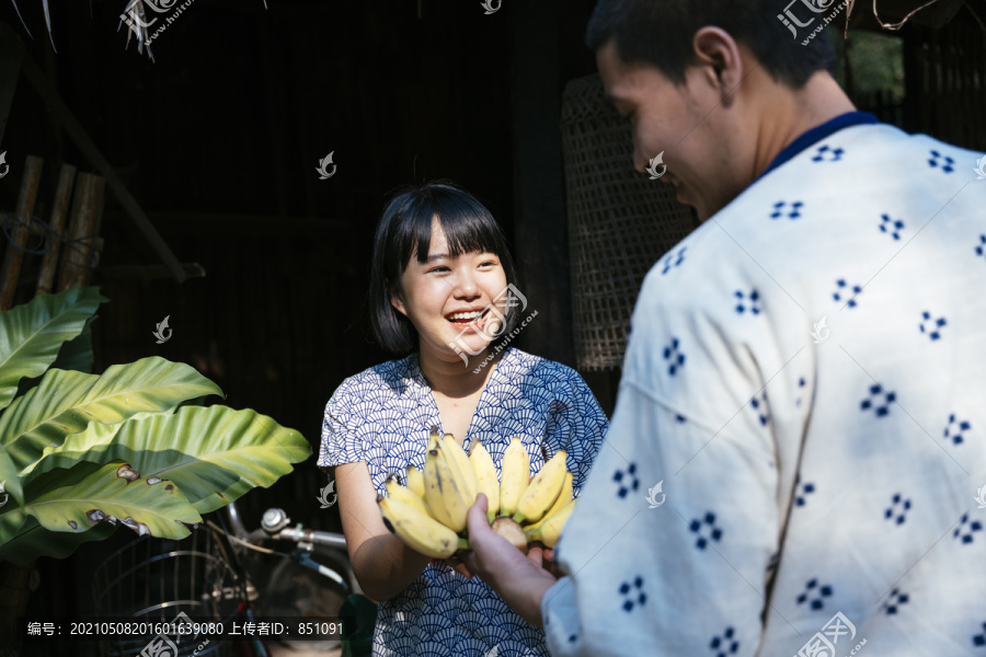 生态旅游-当地农场向顾客出售巴南。游客从可爱的卖家那里买新鲜香蕉。