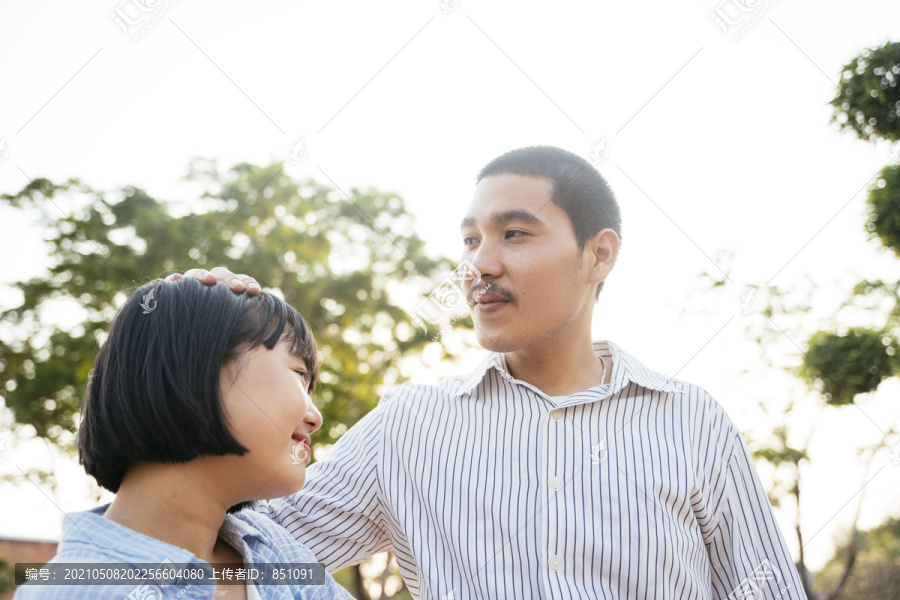 泰国亚裔青年。光头男人把手放在女人头上。爱情场景。
