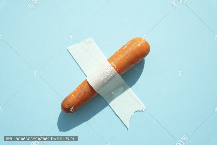 胡萝卜和黄瓜用胶带粘在蓝面包上。